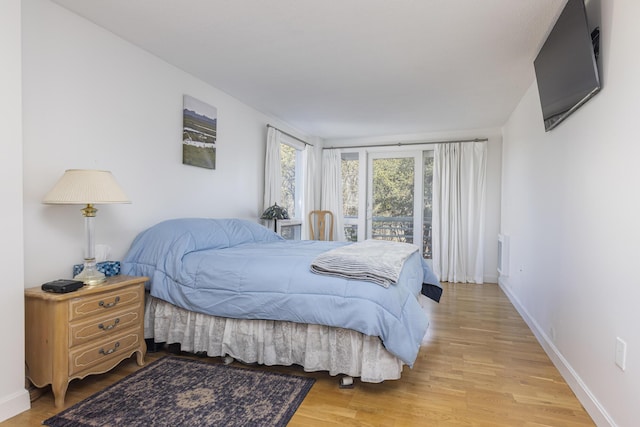 bedroom with baseboards and light wood finished floors