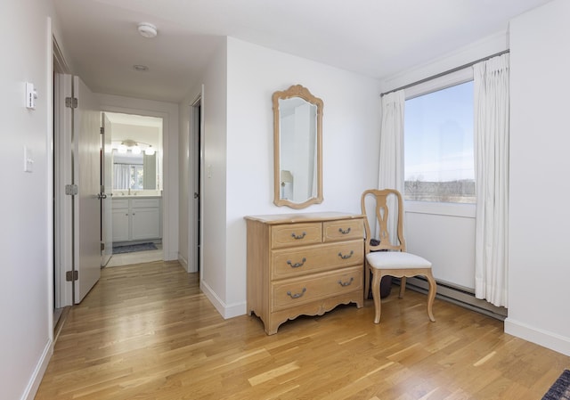 corridor with light wood-style flooring, baseboards, and a wealth of natural light