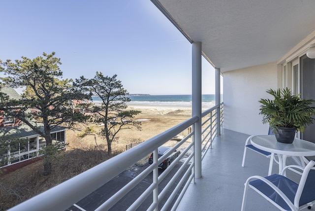 balcony with a water view and a beach view