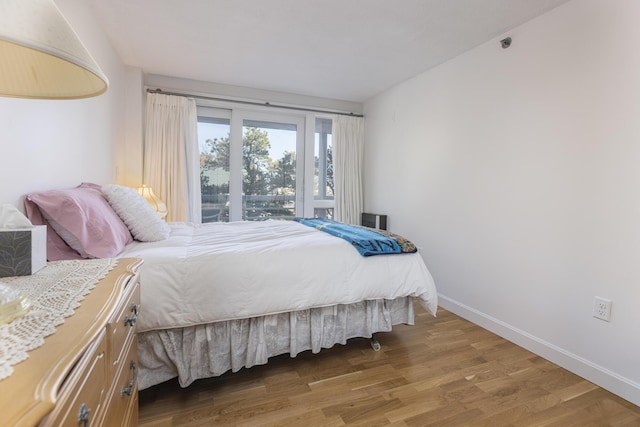 bedroom with light wood-type flooring and baseboards