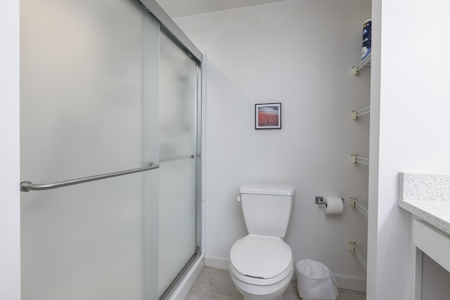 bathroom with tile patterned flooring, a shower stall, baseboards, toilet, and vanity