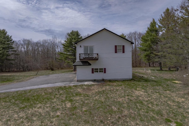 view of side of home with a forest view and a yard