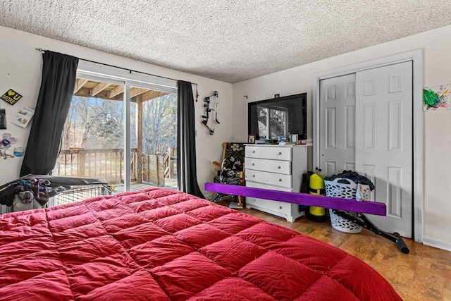 bedroom featuring a closet, wood finished floors, a textured ceiling, and access to exterior