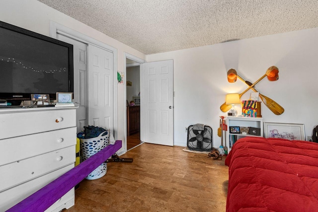 bedroom with wood finished floors and a textured ceiling