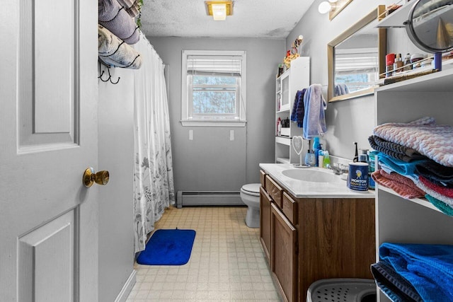 bathroom with tile patterned floors, toilet, a baseboard heating unit, a textured ceiling, and vanity