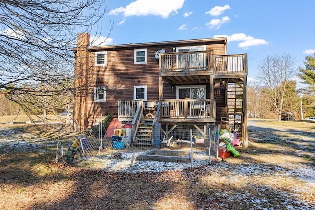 rear view of house with stairway, a chimney, and a deck