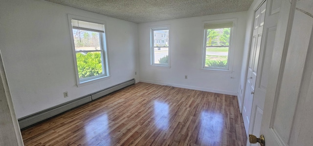 8 Cornerbrook Cir, Windham, ME 04062 - empty room featuring baseboards, a baseboard radiator, a textured ceiling, and wood finished floors