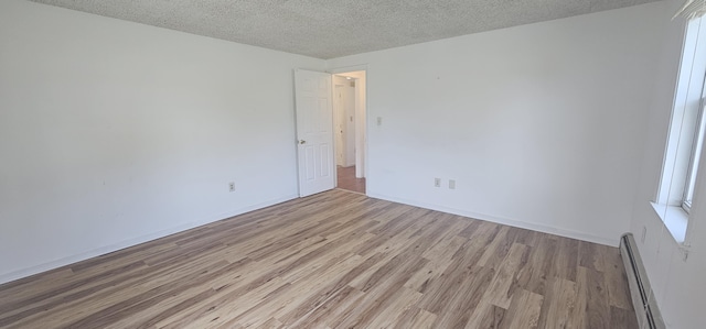 8 Cornerbrook Cir, Windham, ME 04062 - empty room with a textured ceiling, a baseboard heating unit, and light wood-style flooring