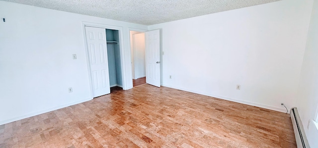 8 Cornerbrook Cir, Windham, ME 04062 - unfurnished bedroom with a closet, wood finished floors, baseboards, a textured ceiling, and a baseboard radiator