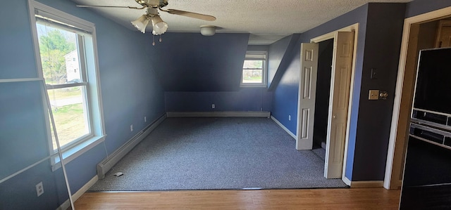 8 Cornerbrook Cir, Windham, ME 04062 - carpeted spare room with wood finished floors, baseboards, ceiling fan, a textured ceiling, and a baseboard heating unit