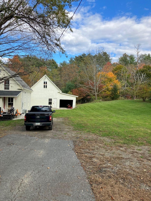 exterior space featuring an outdoor structure, a lawn, and a detached garage