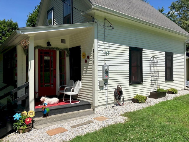 exterior space featuring a porch and roof with shingles