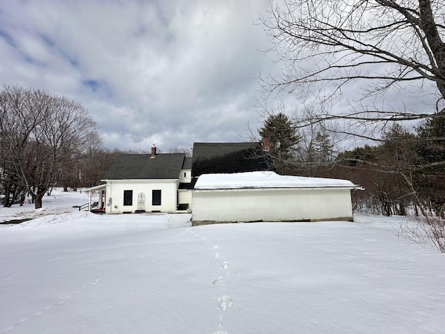 snow covered property with a chimney