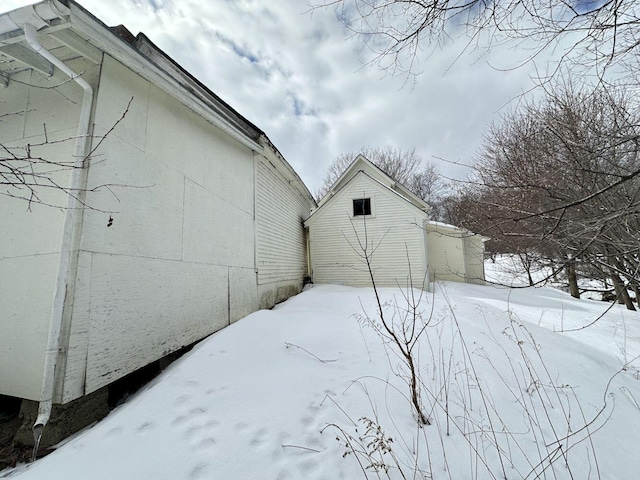 view of snowy exterior featuring an outbuilding