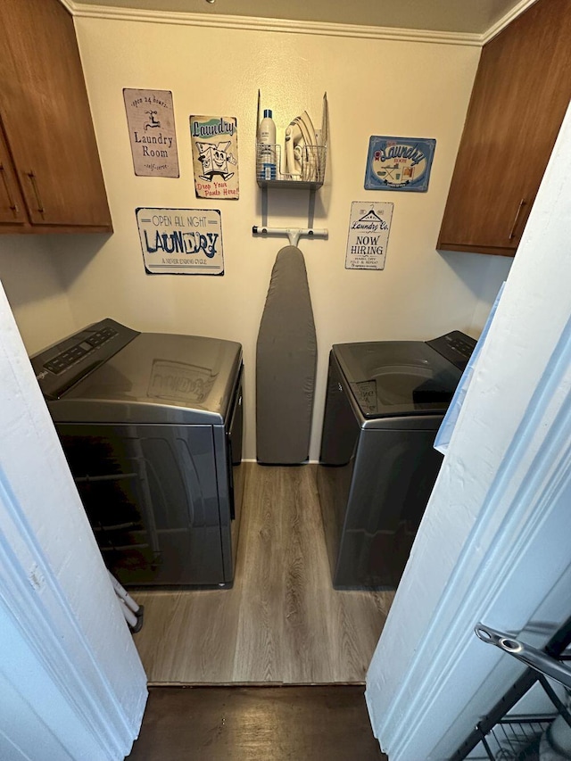 washroom with washer and clothes dryer, dark wood-style floors, and cabinet space