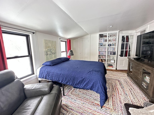 bedroom featuring lofted ceiling and wood finished floors