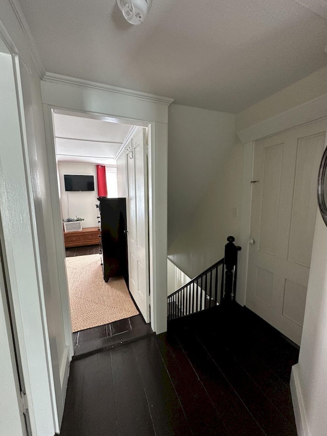 hallway featuring an upstairs landing and dark wood finished floors