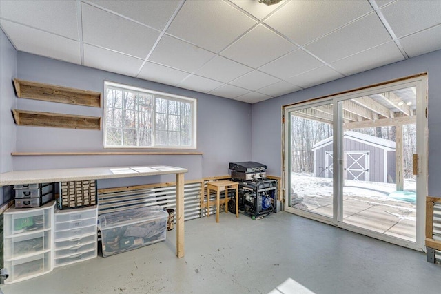 interior space featuring a drop ceiling and concrete floors