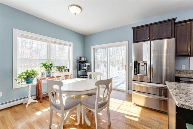 dining room featuring a baseboard radiator and light wood finished floors