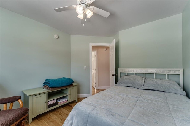 bedroom featuring wood finished floors, baseboards, and ceiling fan