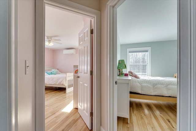 hall with light wood-style flooring and a wall mounted air conditioner