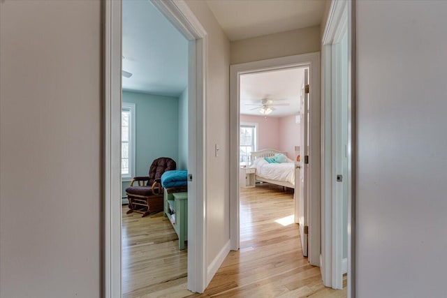 hallway with baseboards and light wood-style floors