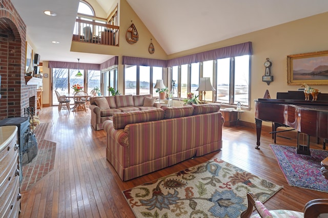 189 Mills Rd, Kennebunkport, ME 04046 - living room featuring wood-type flooring, a fireplace, high vaulted ceiling, and baseboards