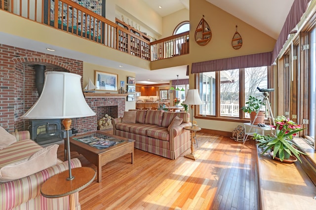 189 Mills Rd, Kennebunkport, ME 04046 - living area featuring baseboards, a wood stove, hardwood / wood-style flooring, and a towering ceiling