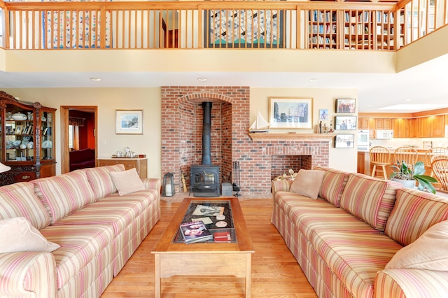 189 Mills Rd, Kennebunkport, ME 04046 - living room featuring a towering ceiling, light wood-type flooring, and a wood stove