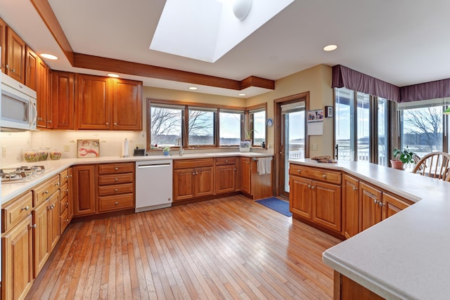 189 Mills Rd, Kennebunkport, ME 04046 - kitchen with white microwave, a healthy amount of sunlight, dishwashing machine, and light wood-style flooring