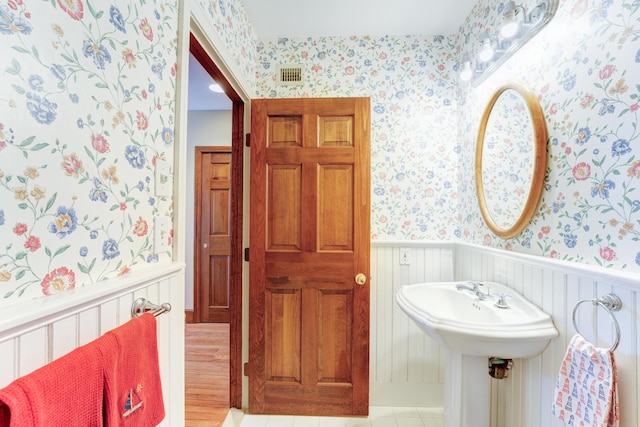 189 Mills Rd, Kennebunkport, ME 04046 - bathroom featuring visible vents, wallpapered walls, and wainscoting