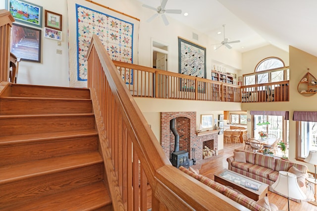 189 Mills Rd, Kennebunkport, ME 04046 - stairway with a wood stove, high vaulted ceiling, a ceiling fan, visible vents, and wood finished floors