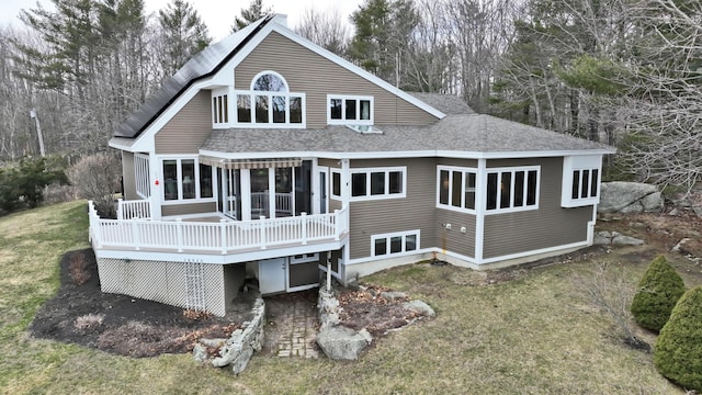 189 Mills Rd, Kennebunkport, ME 04046 - rear view of house featuring a deck, a lawn, a sunroom, and roof with shingles