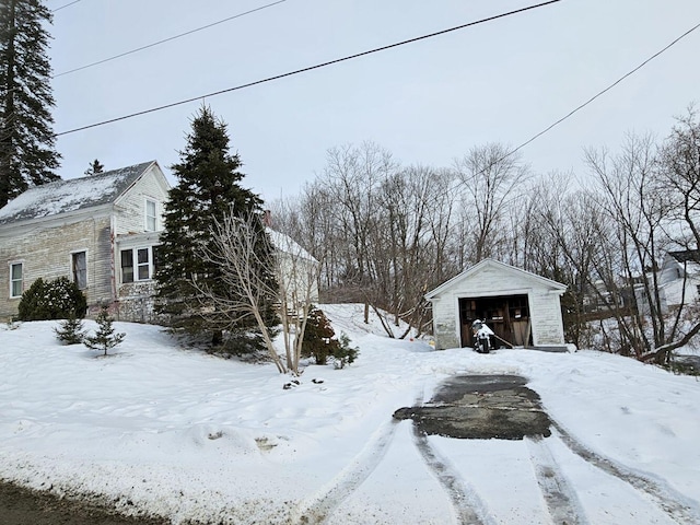 yard covered in snow featuring an outbuilding and a garage