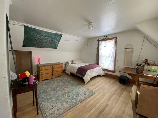 bedroom featuring ceiling fan, vaulted ceiling, and light wood finished floors