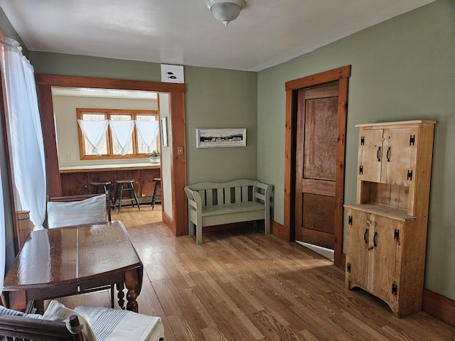 bedroom featuring wood finished floors, baseboards, and a baseboard radiator