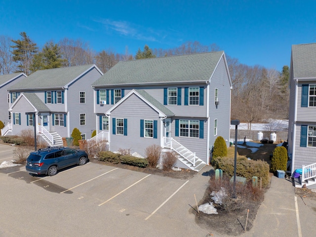 view of front of home featuring uncovered parking and a shingled roof