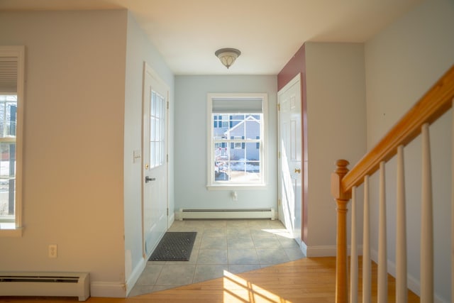 foyer with stairway, light tile patterned floors, baseboards, and baseboard heating