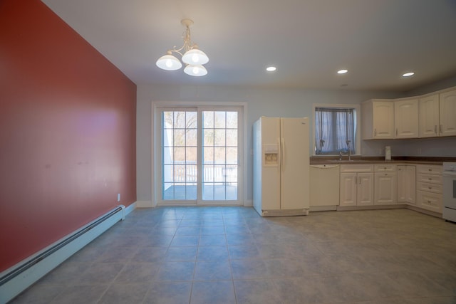 kitchen featuring dark countertops, a baseboard heating unit, decorative light fixtures, white appliances, and white cabinetry