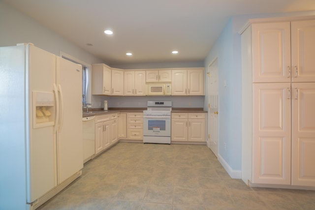 kitchen featuring baseboards, recessed lighting, white cabinets, white appliances, and a sink