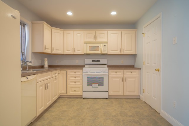 kitchen featuring a sink, recessed lighting, white appliances, light tile patterned floors, and baseboards