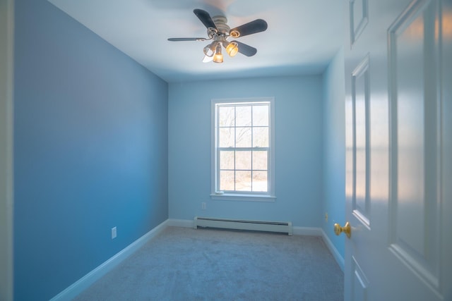 spare room featuring a baseboard heating unit, a ceiling fan, baseboards, and carpet floors