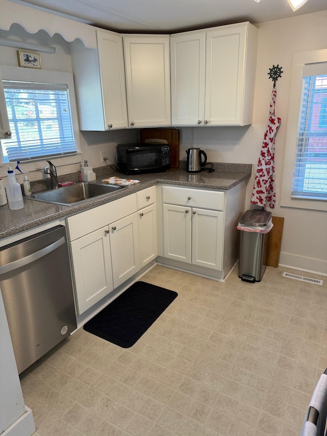 kitchen with visible vents, black microwave, dishwasher, white cabinets, and a sink