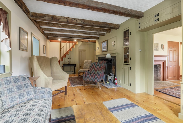 598 Walnut Hill Rd, North Yarmouth, ME 04097 - living area featuring a fireplace, light wood-style floors, stairs, and beam ceiling