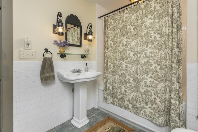 598 Walnut Hill Rd, North Yarmouth, ME 04097 - bathroom featuring tile walls, tile patterned floors, shower / bath combo with shower curtain, toilet, and a wainscoted wall