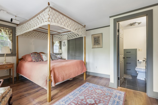 598 Walnut Hill Rd, North Yarmouth, ME 04097 - bedroom with wood finished floors, baseboards, ornamental molding, and ensuite bath