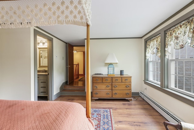 598 Walnut Hill Rd, North Yarmouth, ME 04097 - bedroom with wood finished floors, a baseboard heating unit, a sink, baseboards, and ornamental molding