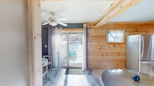 doorway to outside featuring wooden walls, beamed ceiling, and ceiling fan