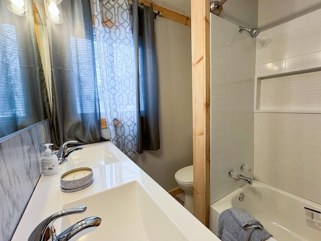 bathroom featuring a sink, toilet, double vanity, and shower / tub combination