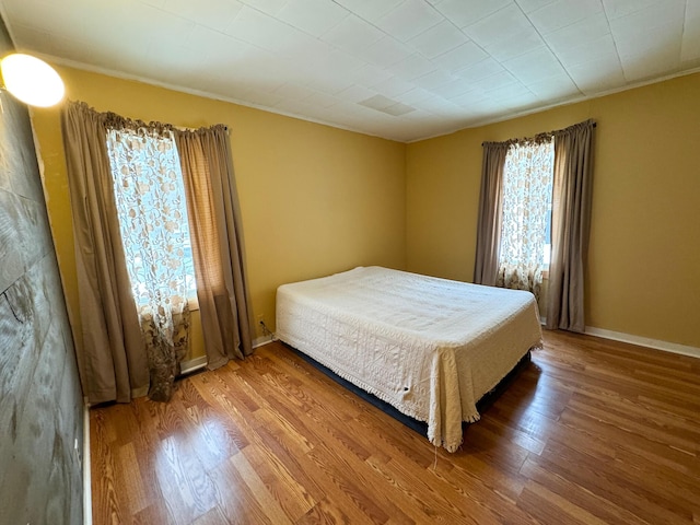 bedroom with wood finished floors and baseboards